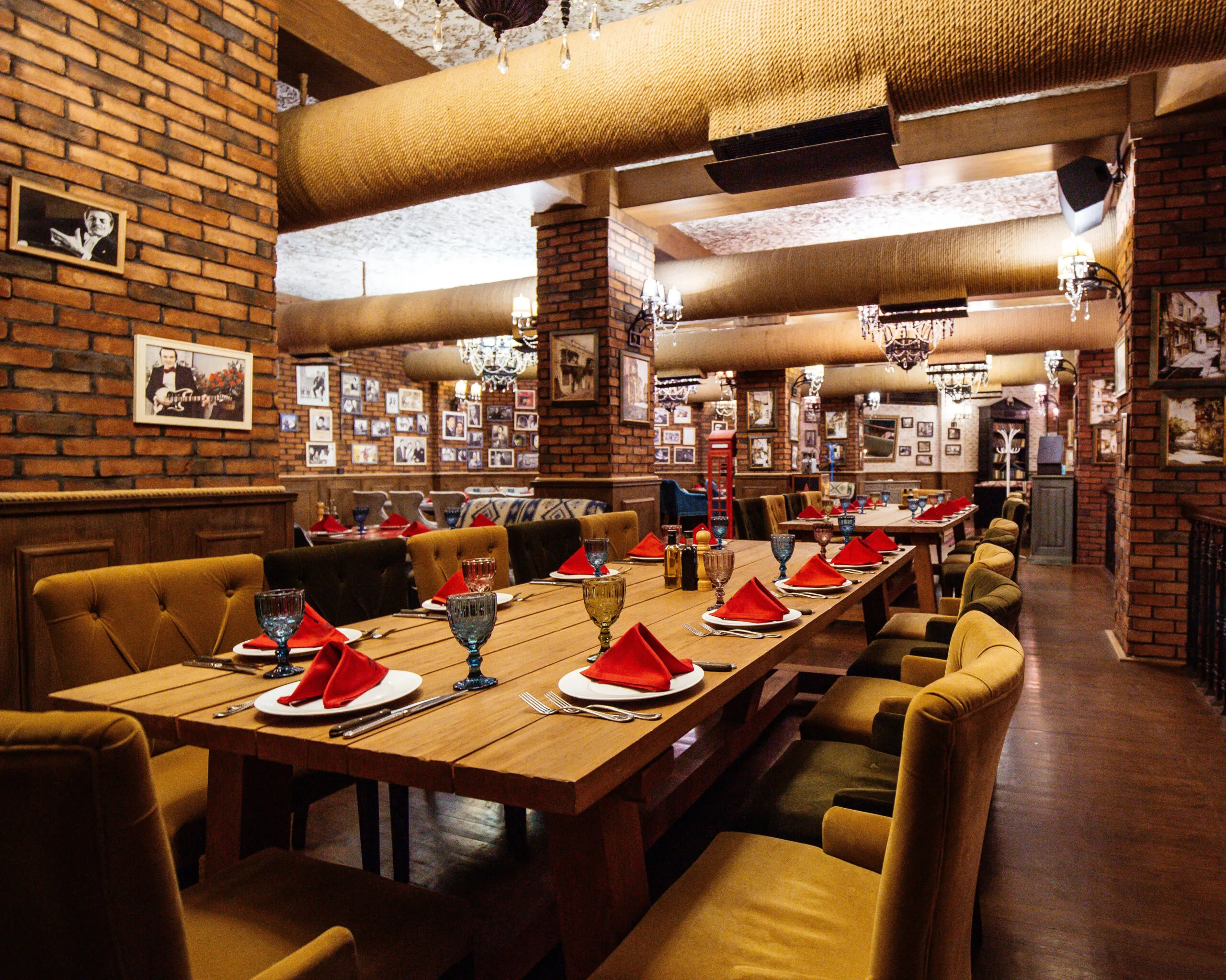restaurant-hall-with-red-brick-walls-wooden-tables-pipes-ceiling-scaled-1.webp
